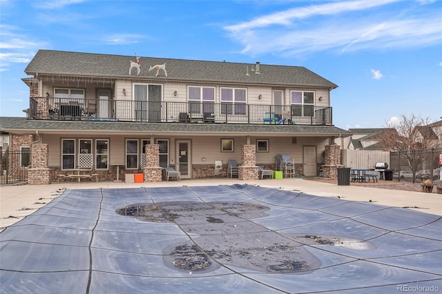 back of house with a covered pool and a patio