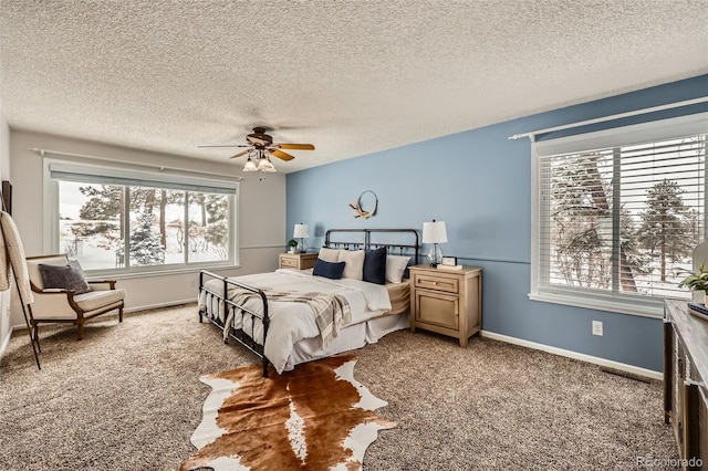 carpeted bedroom with a ceiling fan, a textured ceiling, and baseboards