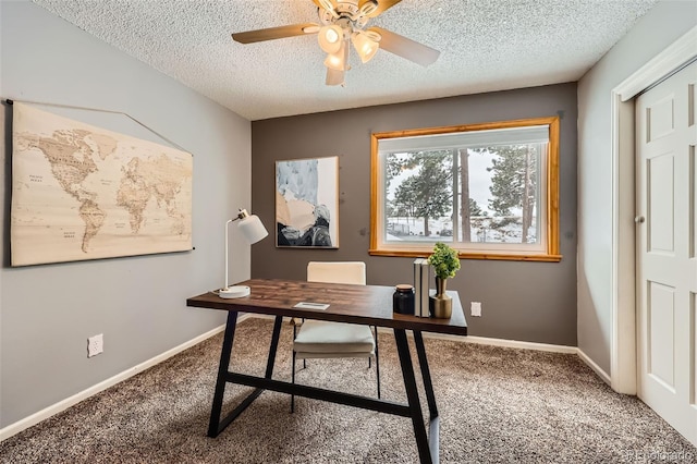 home office with a textured ceiling, carpet flooring, a ceiling fan, and baseboards