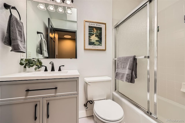 bathroom featuring bath / shower combo with glass door, vanity, and toilet