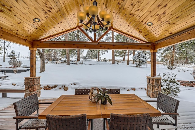 snow covered deck with outdoor dining space and a gazebo