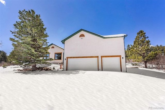 4860 County Road 140, Westcliffe, CO 81252 - view of snow covered exterior with an attached garage and stucco siding