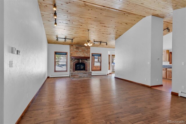 4860 County Road 140, Westcliffe, CO 81252 - unfurnished living room featuring rail lighting, wooden ceiling, a baseboard radiator, baseboards, and a brick fireplace
