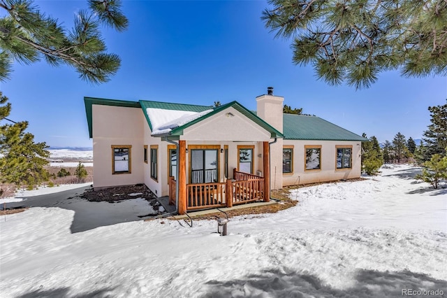 4860 County Road 140, Westcliffe, CO 81252 - snow covered property featuring a chimney, metal roof, and stucco siding