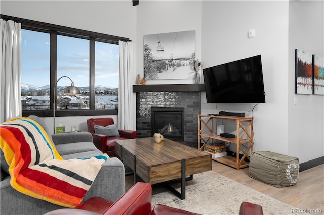 living room with a fireplace, a mountain view, and light hardwood / wood-style floors