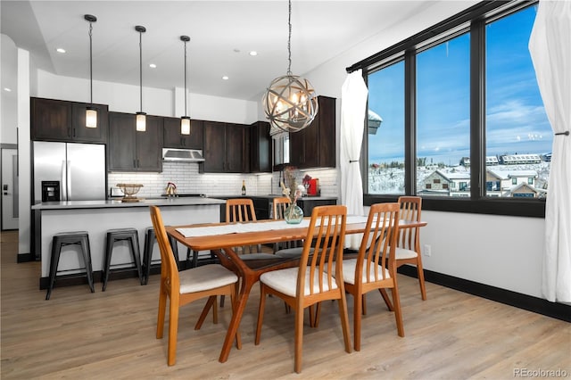 dining room with an inviting chandelier and light hardwood / wood-style flooring