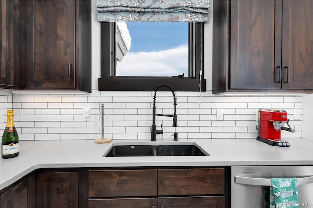 kitchen with tasteful backsplash, stainless steel dishwasher, dark brown cabinetry, and sink