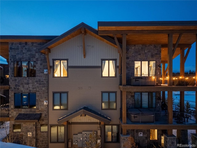 back house at dusk with a balcony