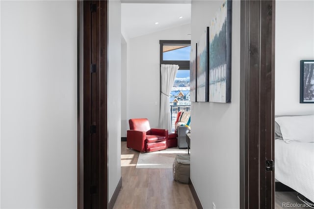 hall with hardwood / wood-style flooring and lofted ceiling