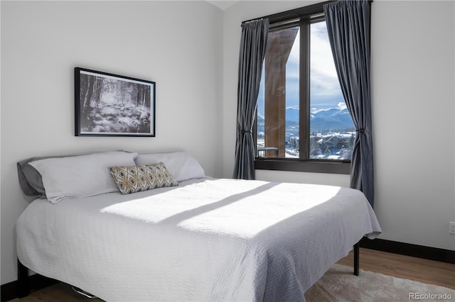 bedroom featuring wood-type flooring and multiple windows