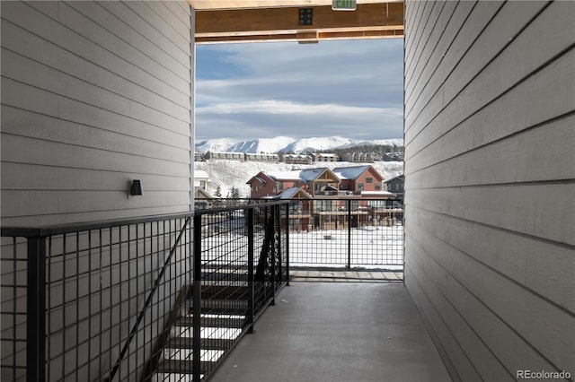 snow covered back of property featuring a mountain view