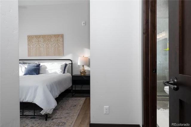 bedroom featuring hardwood / wood-style flooring and ensuite bath