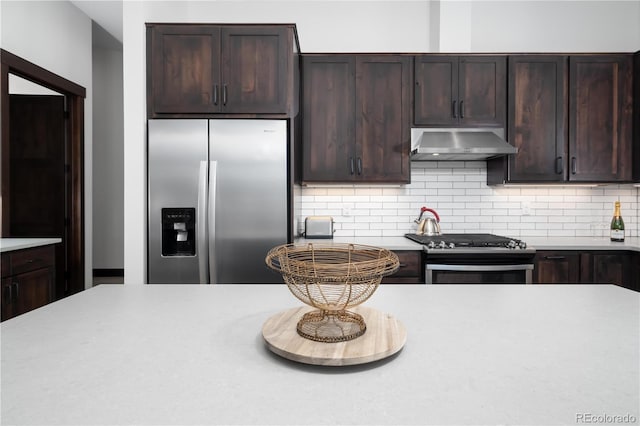 16 Springview Ln Unit A 304, Fraser, CO 80442 - kitchen with extractor fan, stainless steel appliances, light countertops, dark brown cabinets, and tasteful backsplash