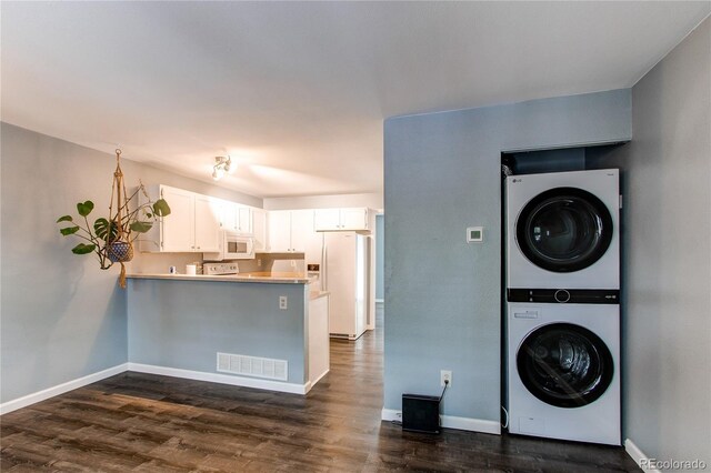 1128 S Ventura Cir Unit K, Aurora, CO 80017 - laundry room featuring stacked washing machine and dryer, dark wood-style flooring, and baseboards