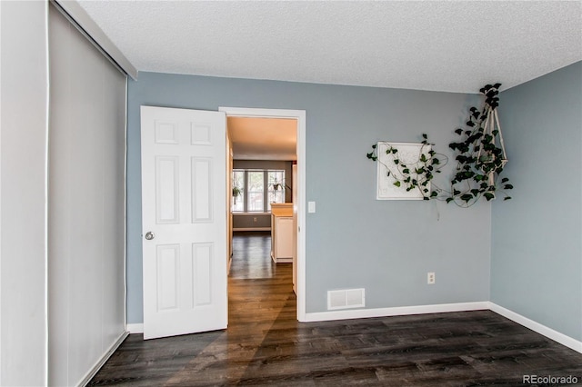 1128 S Ventura Cir Unit K, Aurora, CO 80017 - empty room with dark wood finished floors, baseboards, and a textured ceiling