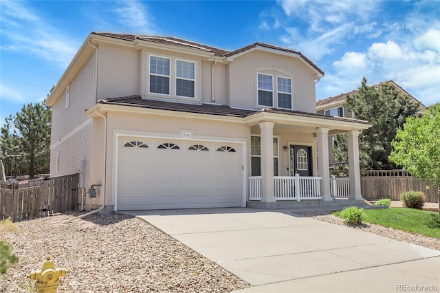 traditional home featuring a porch, a garage, fence, and concrete driveway