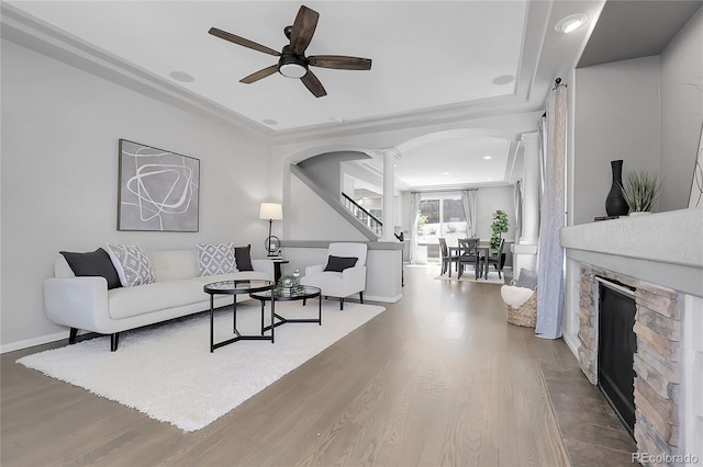 living area featuring arched walkways, decorative columns, ceiling fan, wood finished floors, and recessed lighting