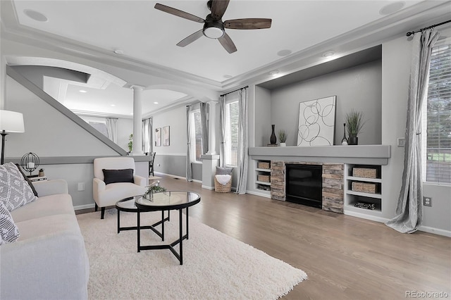 living area featuring plenty of natural light, wood finished floors, a ceiling fan, a fireplace, and recessed lighting