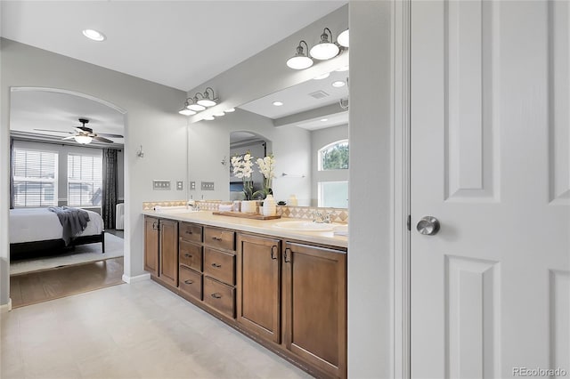 full bathroom with connected bathroom, healthy amount of natural light, double vanity, a ceiling fan, and recessed lighting