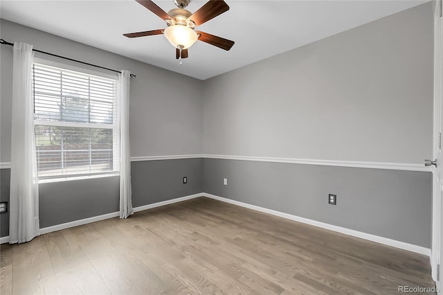 spare room featuring a ceiling fan, baseboards, and wood finished floors