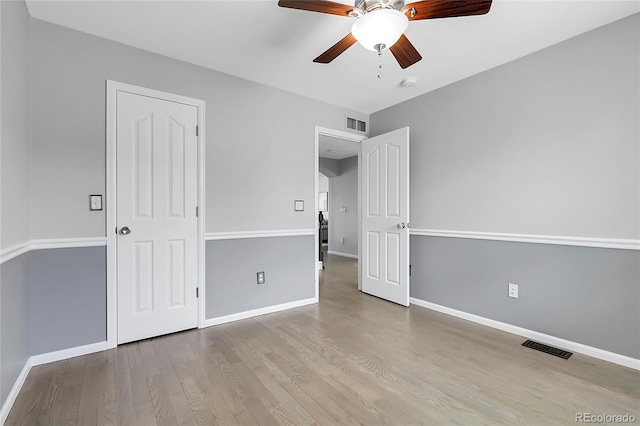 unfurnished bedroom featuring wood finished floors, baseboards, and a ceiling fan
