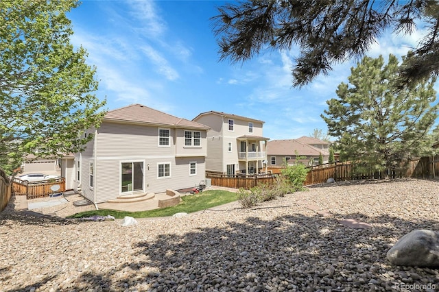rear view of house with a fenced backyard and a patio area