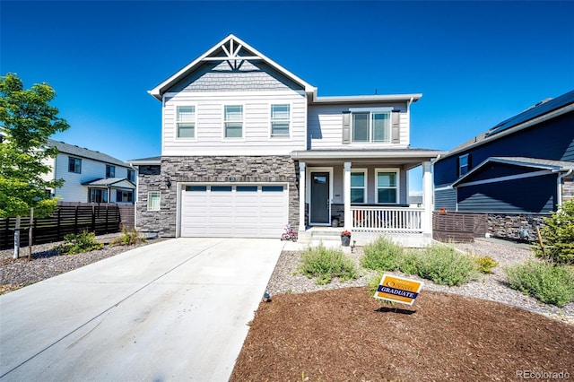 129 S Waterloo St, Aurora, CO 80018 - craftsman house with covered porch, concrete driveway, stone siding, and an attached garage
