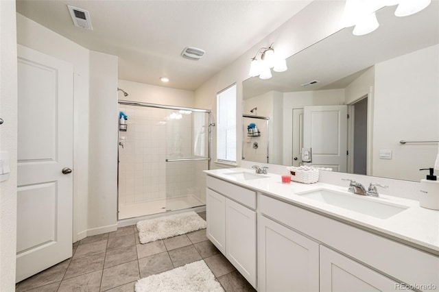 129 S Waterloo St, Aurora, CO 80018 - full bathroom featuring double vanity, a shower stall, and tile patterned flooring
