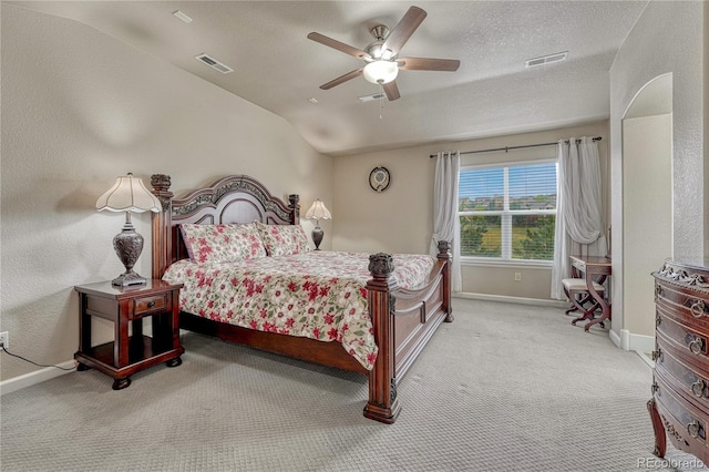 carpeted bedroom featuring baseboards, a ceiling fan, vaulted ceiling, and a textured ceiling