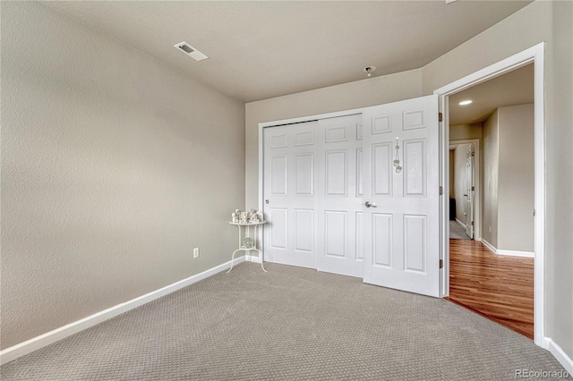 unfurnished bedroom featuring baseboards, carpet, and a closet
