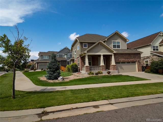 craftsman inspired home featuring a garage, concrete driveway, covered porch, a front yard, and brick siding