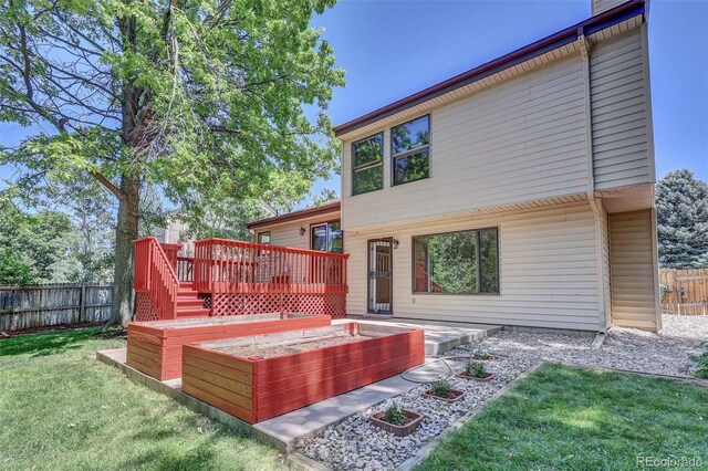 14463 E Wagon Trail Pl, Aurora, CO 80015 - rear view of property with a wooden deck and a vegetable garden