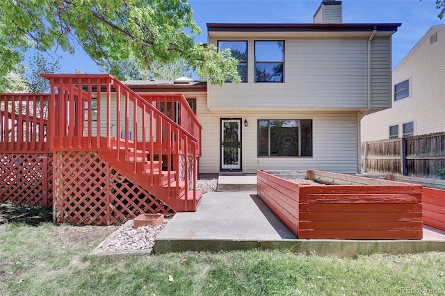 14463 E Wagon Trail Pl, Aurora, CO 80015 - back of property featuring a garden, a chimney, a wooden deck, and stairs