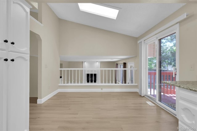 14463 E Wagon Trail Pl, Aurora, CO 80015 - unfurnished room with lofted ceiling, light wood-style flooring, healthy amount of natural light, and a skylight
