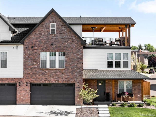 8357 W 68th Ln, Arvada, CO 80004 - view of front facade featuring a balcony, concrete driveway, a garage, brick siding, and a shingled roof