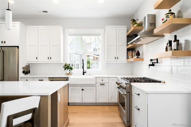 8357 W 68th Ln, Arvada, CO 80004 - kitchen featuring open shelves, stainless steel stove, a sink, light wood-style floors, and wall chimney range hood