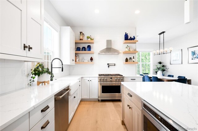 8357 W 68th Ln, Arvada, CO 80004 - kitchen featuring appliances with stainless steel finishes, wall chimney range hood, open shelves, tasteful backsplash, and recessed lighting