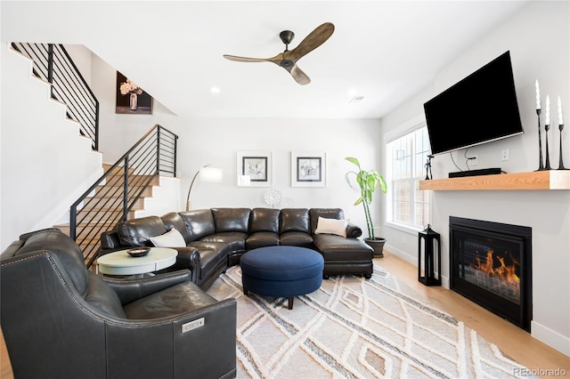 8357 W 68th Ln, Arvada, CO 80004 - living room featuring ceiling fan, stairs, light wood-style flooring, and baseboards
