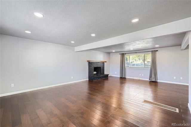 unfurnished living room with baseboards, dark wood-style floors, and a textured ceiling