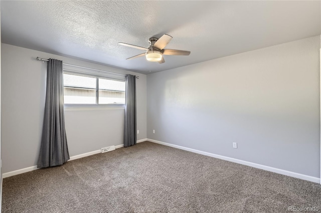 carpeted spare room with baseboards, a ceiling fan, a textured ceiling, and visible vents