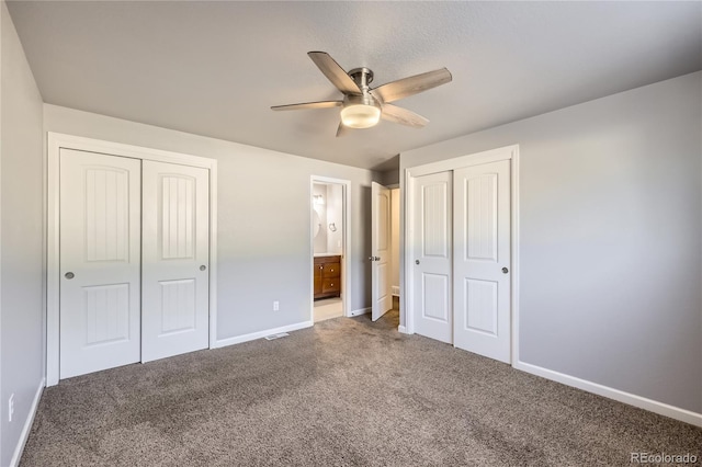 unfurnished bedroom featuring carpet floors, a ceiling fan, baseboards, and ensuite bath