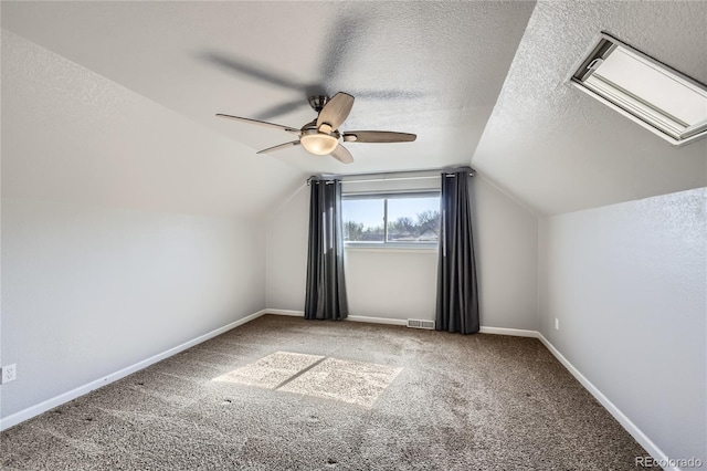 additional living space featuring visible vents, carpet flooring, a ceiling fan, and lofted ceiling