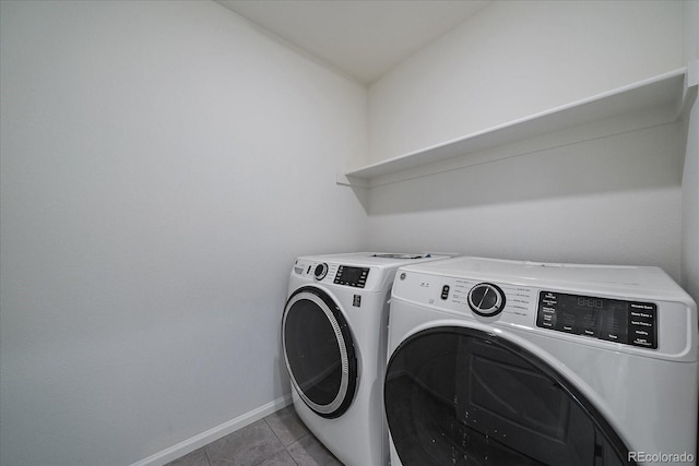 laundry room featuring light tile patterned flooring and washing machine and clothes dryer