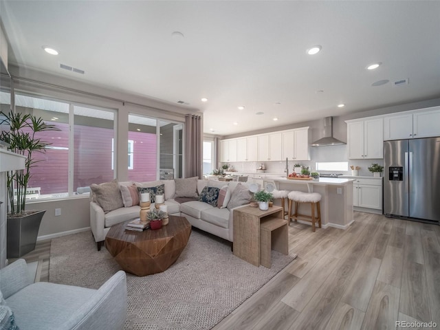 living room with sink and light hardwood / wood-style flooring