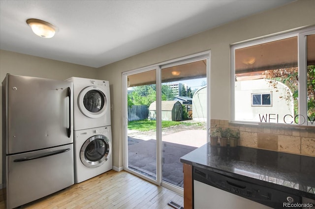 2415 Chase St, Edgewater, CO 80214 - laundry area with stacked washer / dryer and light wood-style flooring