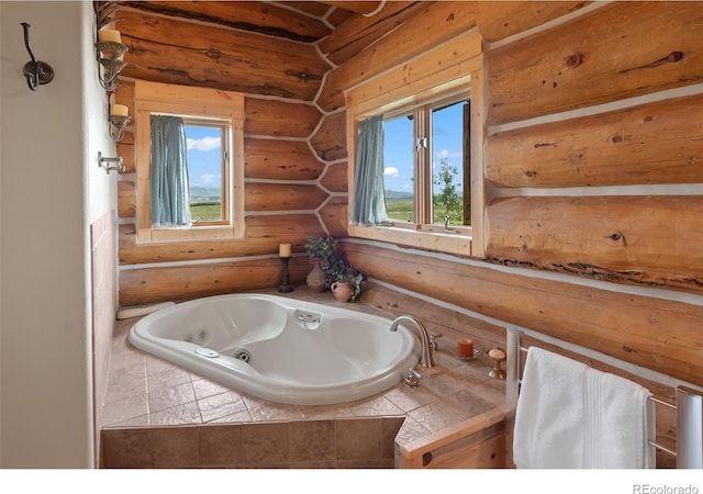 1000 N County Road 33, Como, CO 80432 - bathroom featuring a tub with jets, log walls, and plenty of natural light
