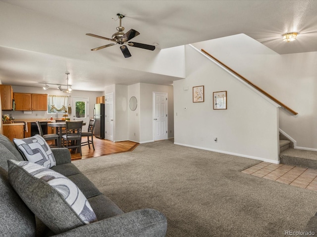 12555 Eastlake Dr, Thornton, CO 80241 - living room featuring light colored carpet, ceiling fan, and stairway