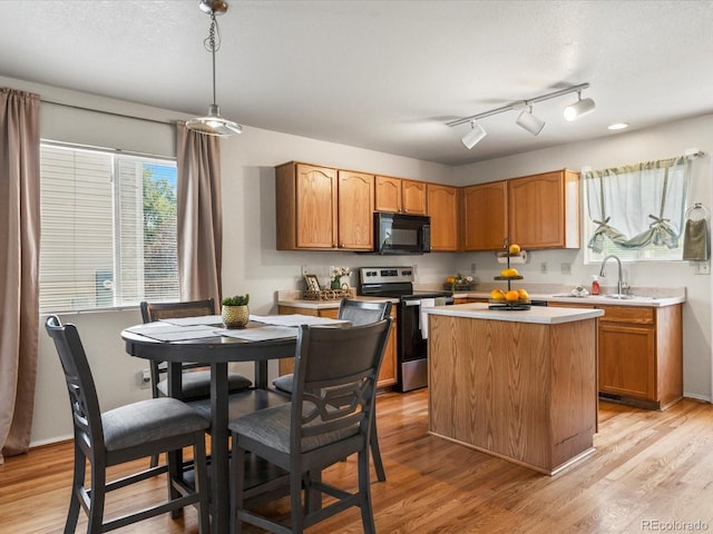12555 Eastlake Dr, Thornton, CO 80241 - kitchen with black microwave, stainless steel electric range oven, light countertops, light wood-type flooring, and a center island