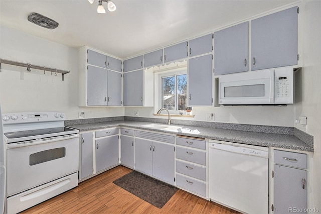 kitchen featuring gray cabinetry, white appliances, sink, and light wood-type flooring