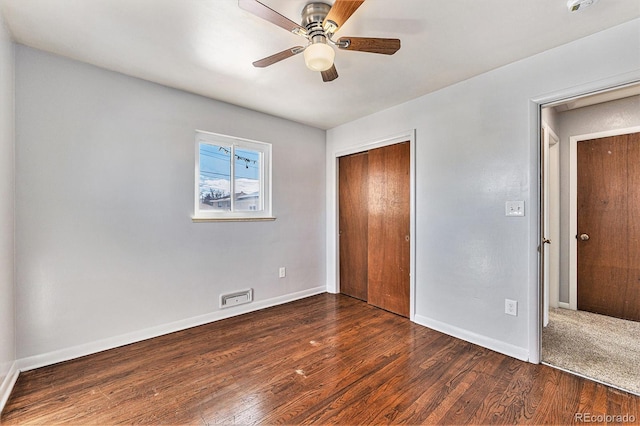 unfurnished bedroom with dark wood-type flooring, ceiling fan, and a closet